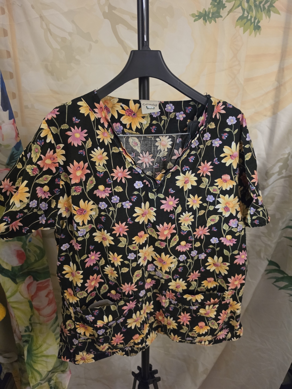 Cottonality black floral print V-neck short-sleeve scrub top features a vibrant